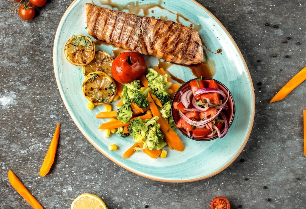 fried salmon with vegetables on the table __